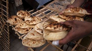  A worker collects Egyptian traditional 'baladi' flatbread, at a bakery, in Cairo, Egypt.