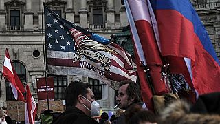 QAnon, russische und österreichische Fahnen bei einer Anti-Vax-Kundgebung in Wien, 12. März 2022
