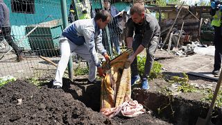Orosz légitámadásban életét vesztő polgári áldozat holttestét exhumálják a kelet-ukrajnai Malaja Rohan faluban 2022. május 16-án - képünk illusztráció.
