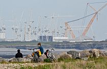 Des adolescents sont assis près du site de la centrale nucléaire de Hinkley Point en construction dans le Somerset, dans le sud-ouest de l'Angleterre, le 21 avril 2022.