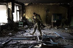 A Ukrainian serviceman inspects a school damaged during a battle between Russian and Ukrainian forces in the village of Vilkhivka near Kharkiv on 20 May 2022