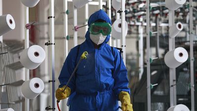 Un employé de Songyo Knitwear Factory à Pyongyang désinfecte un atelier, le 18 mai 2022.