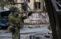 A Russian soldier gets his weapon ready while patrolling a destroyed part of the Illich Iron & Steel Works Metallurgical Plant in Mariupol, 18 May 2022