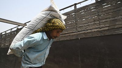 Un ouvrier charge un sac de blé sur un train de marchandises à la gare de Chawa Pail à Khanna, dans l'État du Pendjab, le 19 mai 2022. 