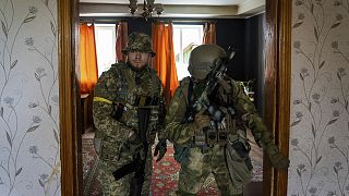 Ukrainian servicemen inspect a house during a reconnaissance mission in a recently retaken village on the outskirts of Kharkiv, on 14 May 2022