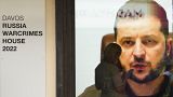 Владимир Зеленский на экране в выставочном павильоне Давоса, который окрестили "российский дом военных преступлений"