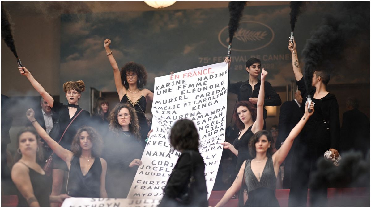 أعضاء الحركة النسوية "Les Colleuses" يرفعون لافتة تحمل أسماء 129 امرأة توفين نتيجة العنف الأسري منذ مهرجان كان السينمائي الأخير.
