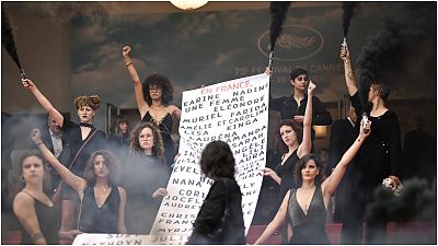 أعضاء الحركة النسوية "Les Colleuses" يرفعون لافتة تحمل أسماء 129 امرأة توفين نتيجة العنف الأسري منذ مهرجان كان السينمائي الأخير.