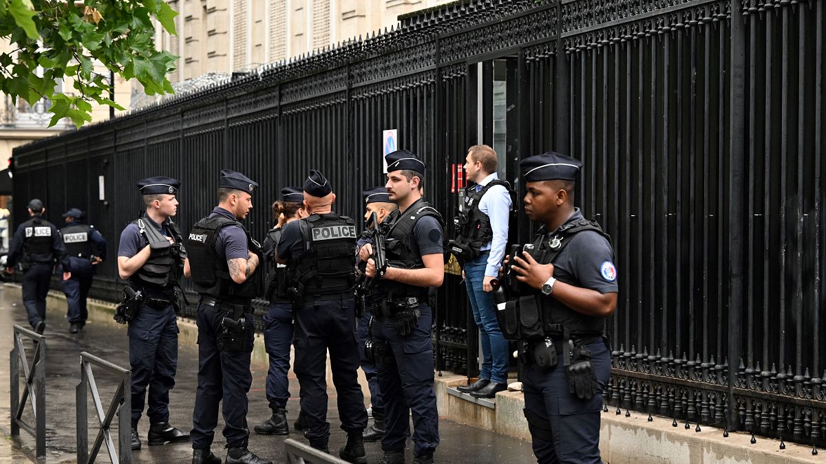 French policemen take position outside the Qatar Embassy in Paris on May 23. 2022, following an incident during which a security guard died.