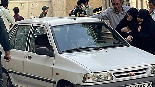 Angehörige von Hassan Sayyad Khodaei stehen neben dem Fahrzeug des hochrangigen Offiziers der Revolutionsgarden kurz nach dessen Mord in Teheran am Sonntag, 22. Mai 2022