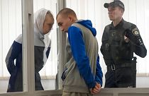 Der Beschuldigte im Zwiegespräch mit einer Übersetzerin im Gerichtssaal in Kiew