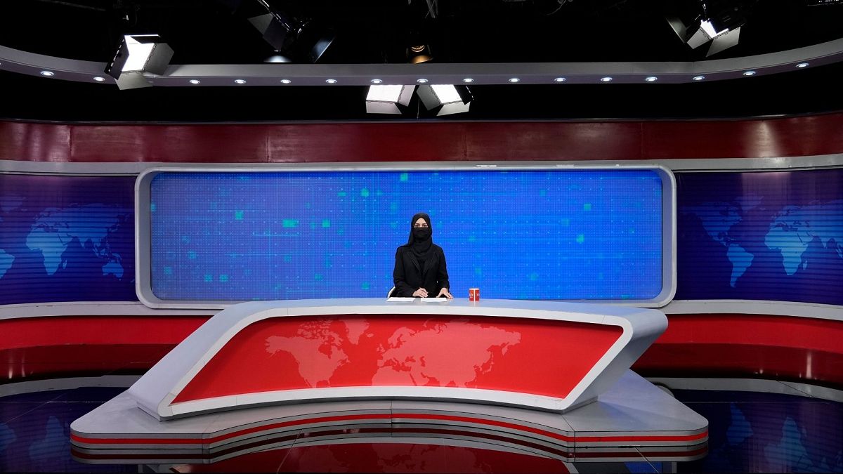 خاطره احمدی، مجری تلویزیون طلوع در حال خواندن اخبار با چهره پوشیده شده طبق دستور طالبان.