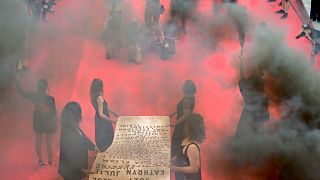 أعضاء الحركة النسوية "Les Colleuses" ترفعن لافتة تحمل أسماء 129 امرأة توفين نتيجة العنف الأسري علر السجادة الحمراء لمهرجان كان السينمائي في فرنسا.