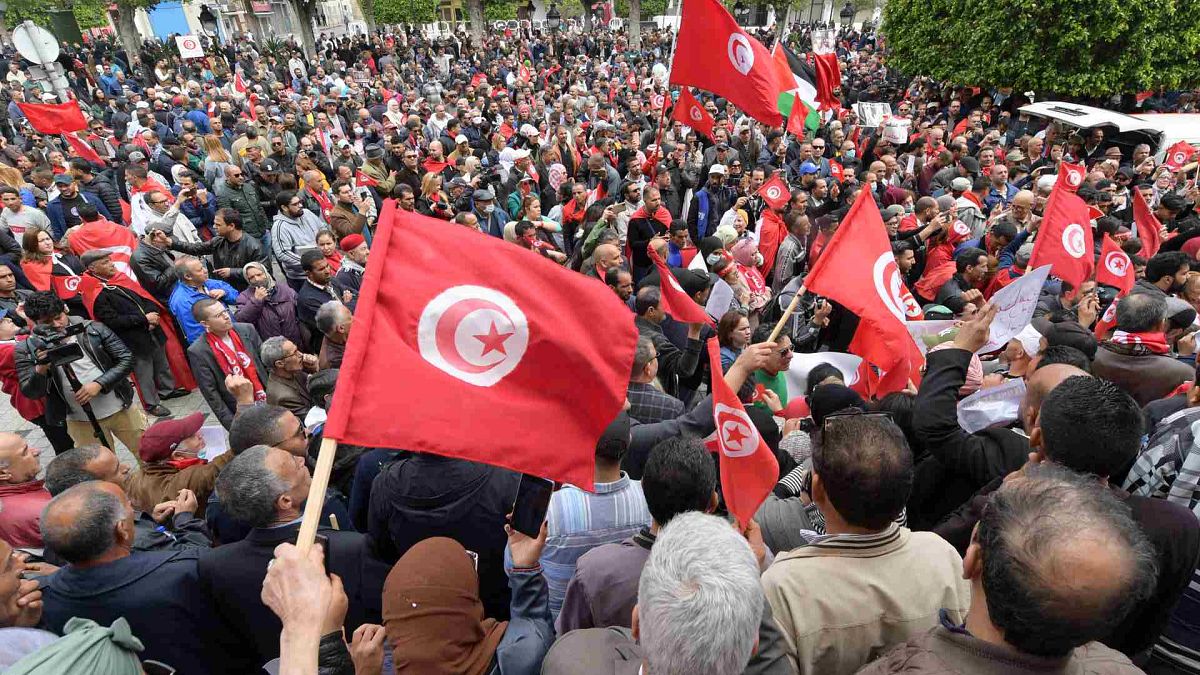 متظاهرون تونسيون يرددون شعارات ويلوحون بعلم بلادهم دعما للرئيس قيس سعيد، في العاصمة تونس، 8 مايو 2022