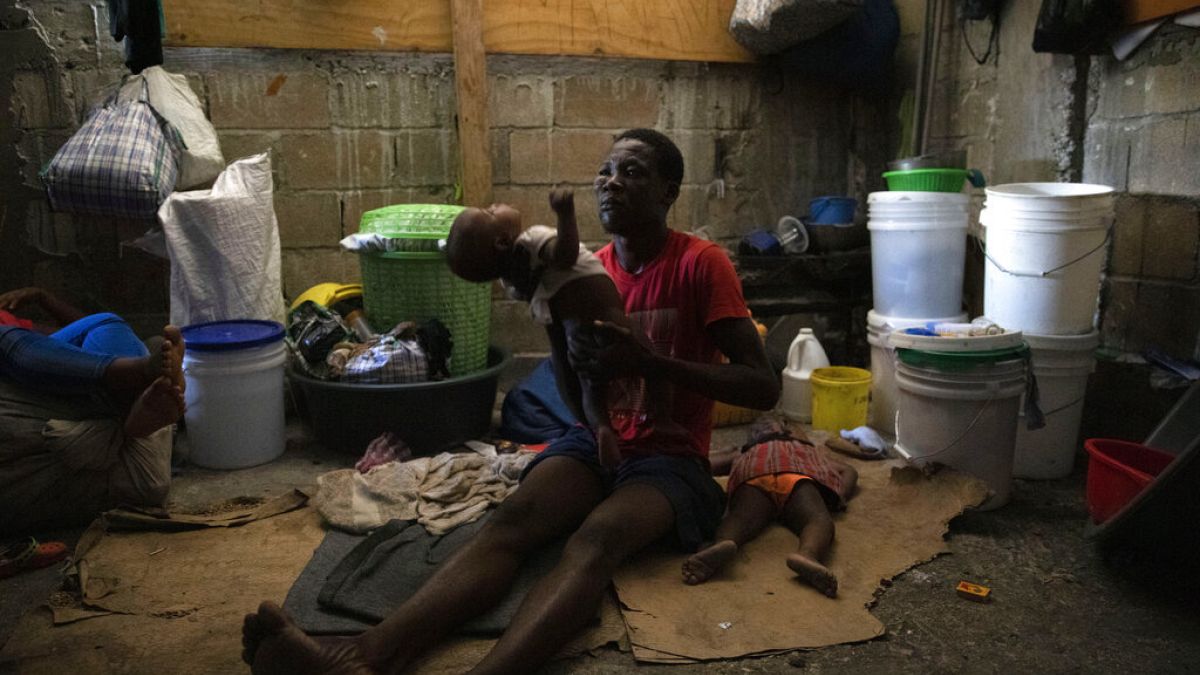 Ideiglenes szálláson élő család Haitin