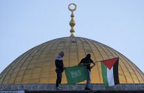 Masked Palestinians carry Palestinian & Hamas flags during Eid al-Fitr celebrations next to Dome of Rock Mosque in Al-Aqsa Mosque compound in Old City of Jerusalem, May 2 2022