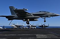 طائرة مقاتلة من طراز F / A-18 هورنت تهبط على سطح حاملة الطائرات الأمريكية التي تعمل بالطاقة النووية-23 آذار 2022