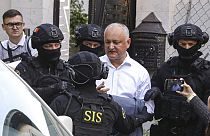 Members of Moldova's Information and Security service (SIS) escort former Moldovan President Igor Dodon to a van after he was detained at his house in Chisinau