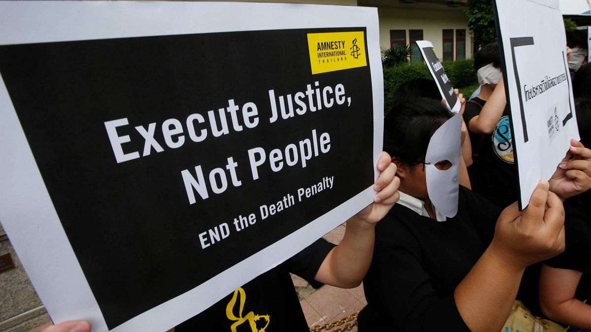 نشطاء منظمة العفو الدولية يحملون ملصقات أثناء تجمع أمام سجن بانغكوان المركزي في بانكوك، تايلاند، الثلاثاء، 19 يونيو 2018