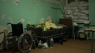 Fekvőbeteg egy elbarikádozott ablakú kórteremben, a kelet-ukrajnai Pokrovszk kórházában