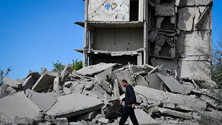 A local resident walks next to a house destroyed in a Russian shelling in Kramatorsk, Ukraine, Wednesday, May 25, 2022.