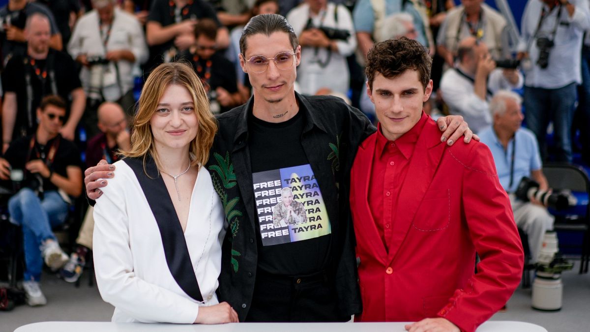 Director Maksym Nakonechnyi, centre, poses with Rita Burkovska and Lyubomyr Valivots at the photo call for the film 'Butterfly Vision' in Cannes, France. 25 March 2022.