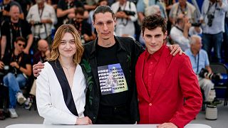 Director Maksym Nakonechnyi, centre, poses with Rita Burkovska and Lyubomyr Valivots at the photo call for the film 'Butterfly Vision' in Cannes, France. 25 March 2022.