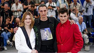 Le réalisateur Maksym Nakonechnyi, au centre, avec Rita Burkovska et Lyubomyr Valivots lors de la séance de photos pour "Butterfly Vision" à Cannes, mercredi 25 mai 2022.
