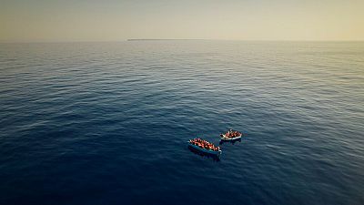 A group of migrants wait to be assisted by a team from the Spanish NGO Open Arms, around 20 miles southwest of Italy, Thursday July 29, 2021.