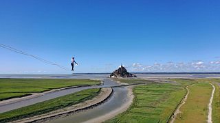 Nathan Paulin walks 2.2km along a tightrope to Mont Saint-Michel