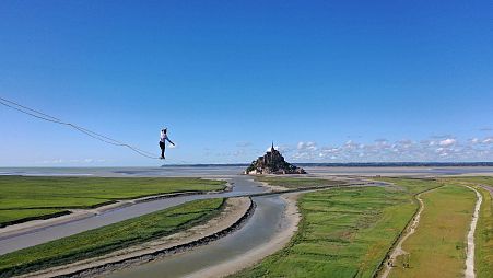 Nathan Paulin walks 2.2km along a tightrope to Mont Saint-Michel