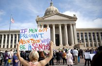 امرأة تحمل لافتة تعترض على حظر الاجهاض أمام مبنى الكابيتول بولاية أوكلاهوما.