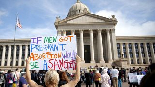امرأة تحمل لافتة تعترض على حظر الاجهاض أمام مبنى الكابيتول بولاية أوكلاهوما.