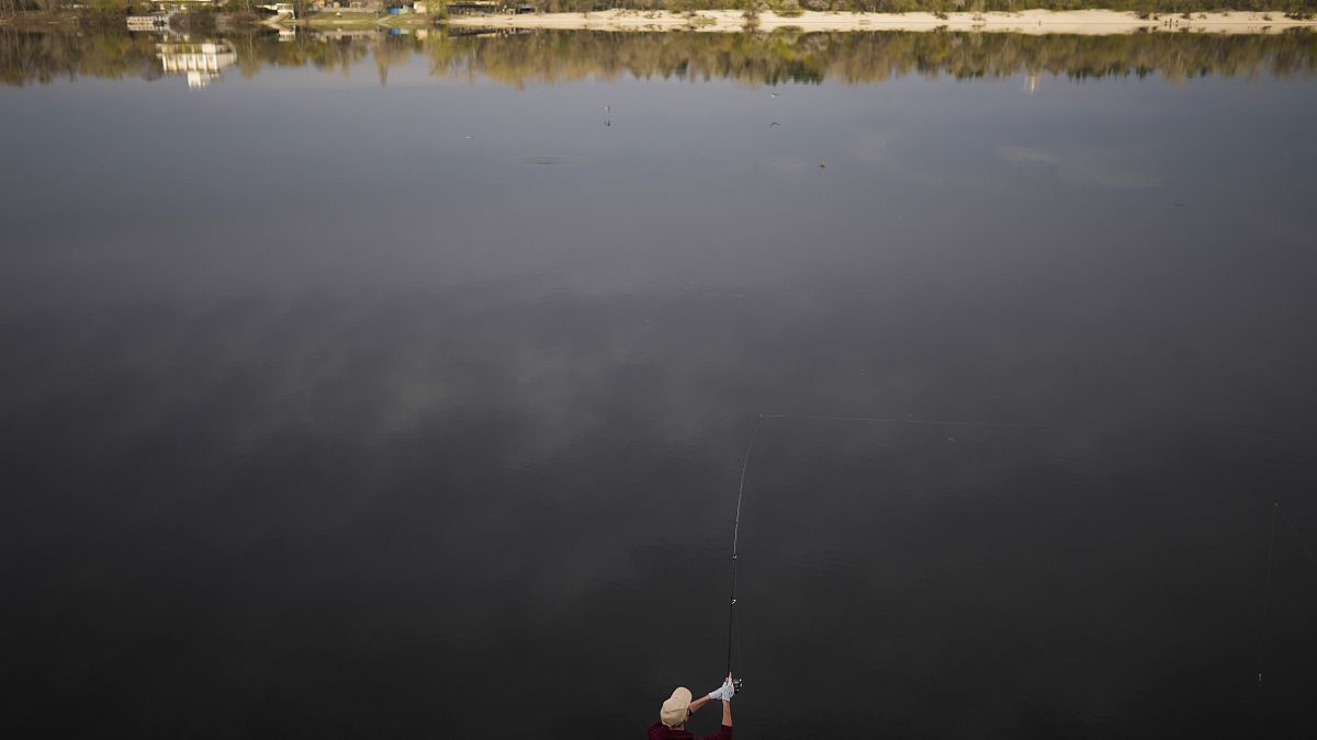 Egy halász a Dnyipro folyón az ukrajnai Kijevben 2022. április 25-én, hétfőn.