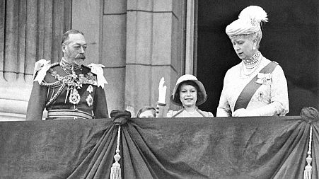 King George V, Princess Elizabeth and Her Majesty Queen Mary on the balcony of Buckingham Palace in London on May 6, 1935, as Elizabeth practices her signature wave.