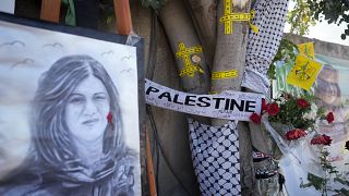 يُظهر الشريط الأصفر ثقوب الرصاص على شجرة التي كانت تقف بجانبها الصحفية الفلسطينية شيرين أبو عاقلة لحظة مقتلها في 19 مايو، 2022