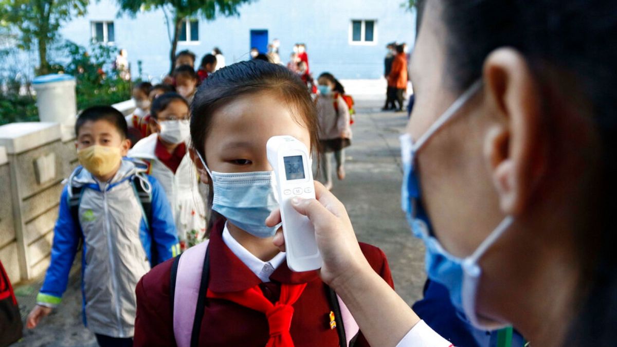 قياس درجة حرارة جسم التلاميذ قبل دخولهم  للمساعدة في الحد من انتشار فيروس كورونا- بيونغ يانغ، كوريا الشمالية