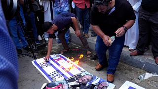  متظاهرون يحرقون صوراً لأعلام إسرائيل ونفتالي بينيت ورئيس أركان الجيش الإسرائيلي والنائب الإسرائيلي إيتامار بن غفير خلال احتجاج على"مسيرة الأعلام"-غزة 25 مايو 2022