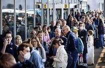 Travellers queue outside a departure hall at Schiphol airport during recent strikes.
