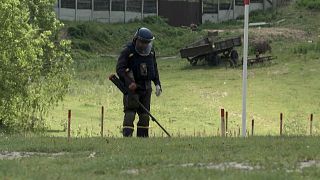 Ukrainian deminers search for unexploded material.