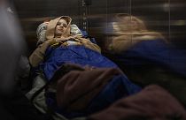 Nastia Kuzik, 21, is carried on a stretcher in a lift while being transported by a medical team to Germany, at a public hospital in Kyiv on 5 May 2022