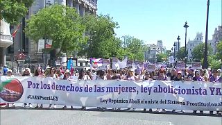 متظاهرون يحملون لافنات خلال مسيرة لمكافحة قوانين الدعارة في مدريد، إسبانيا