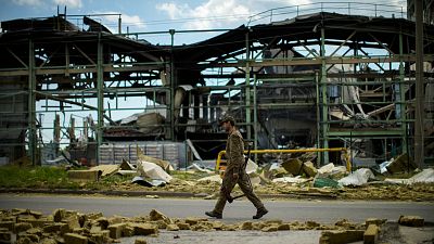 Un militaire ukrainien passe devant une usine détruite par un bombardement russe à Bakhmout, dans l'est de l'Ukraine, samedi 28 mai 2022.