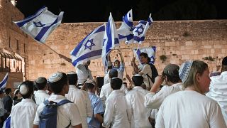 إسرائيليون يرقصون ويلوحون بالأعلام الإسرائيلية عشية يوم القدس، قرب حائط البراق في البلدة القديمة القدس.
