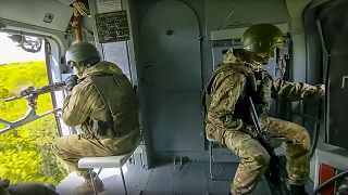 Russian soldiers sit onboard of a Mi-8 helicopter of the Russian air force during a mission at an undisclosed location in Ukraine