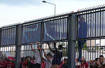 Szurkolók próbálnak átmászni a párizsi stadion kerítésén a BL-döntő helyszínén 2022. május 28-án