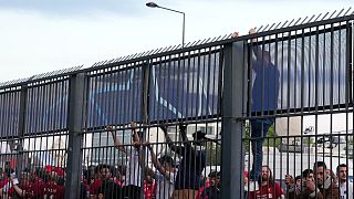 Szurkolók próbálnak átmászni a párizsi stadion kerítésén a BL-döntő helyszínén 2022. május 28-án
