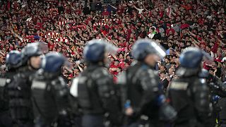 Riot police watch Liverpool fans during the Champions League final soccer match between Liverpool and Real Madrid at the Stade de France on 28 May 2022