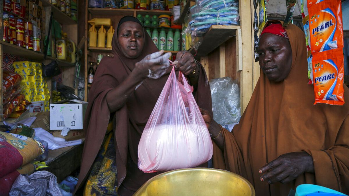 A woman buys wheat flour in Mogadishu, Somali where prices are up 45 per cent since Russia's invasion of Ukraine