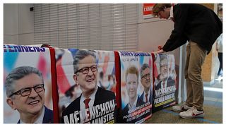 أحد مؤيدي الزعيم اليساري جان لوك ميلينشون يضع ملصقات انتخابية كتب عليها "ميلينشون رئيس الوزراء" 05/05/2022